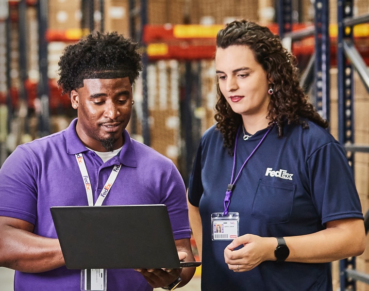 Facility Operation Memebers viewing laptop in a warehouse