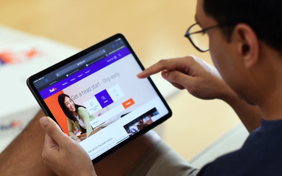 User on tablet viewing fedex.com site